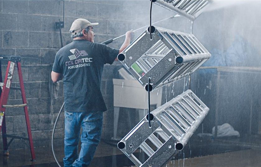 Pressure washing hung trusses before powder coating