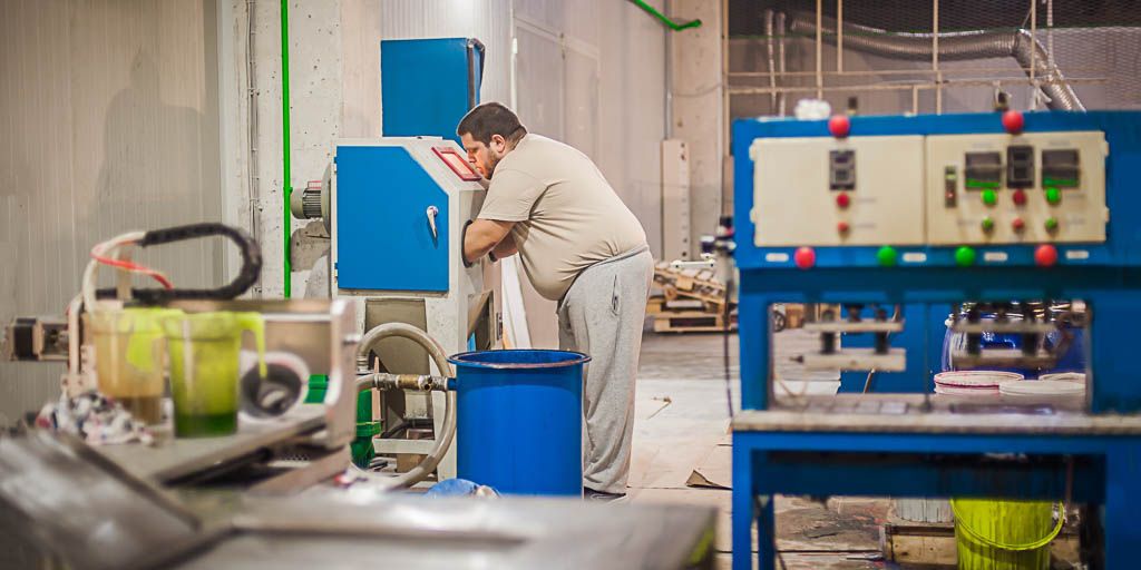 Technician working at the sand blasting cabinet